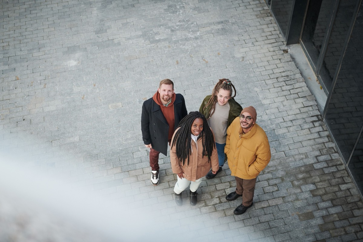 A group of people of different ages and backgrounds standing together, looking upward.